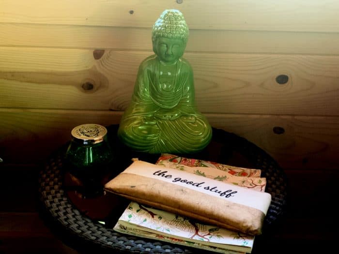 Jade buddha, a small bag labeled 'the good stuff' and coloring books on top of a table